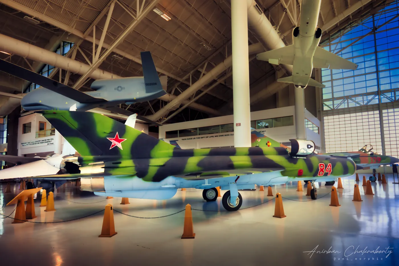 A camouflaged Soviet-built fighter ringed by traffic cones in the hangar