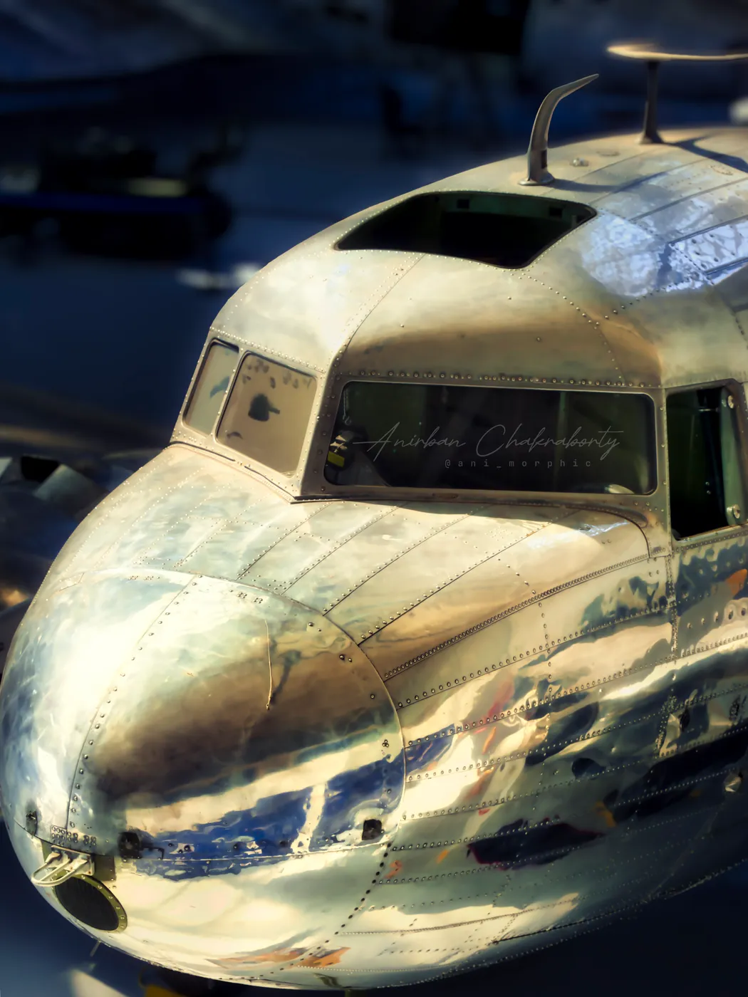 The hangar reflected in the polished nose of a transport aircraft
