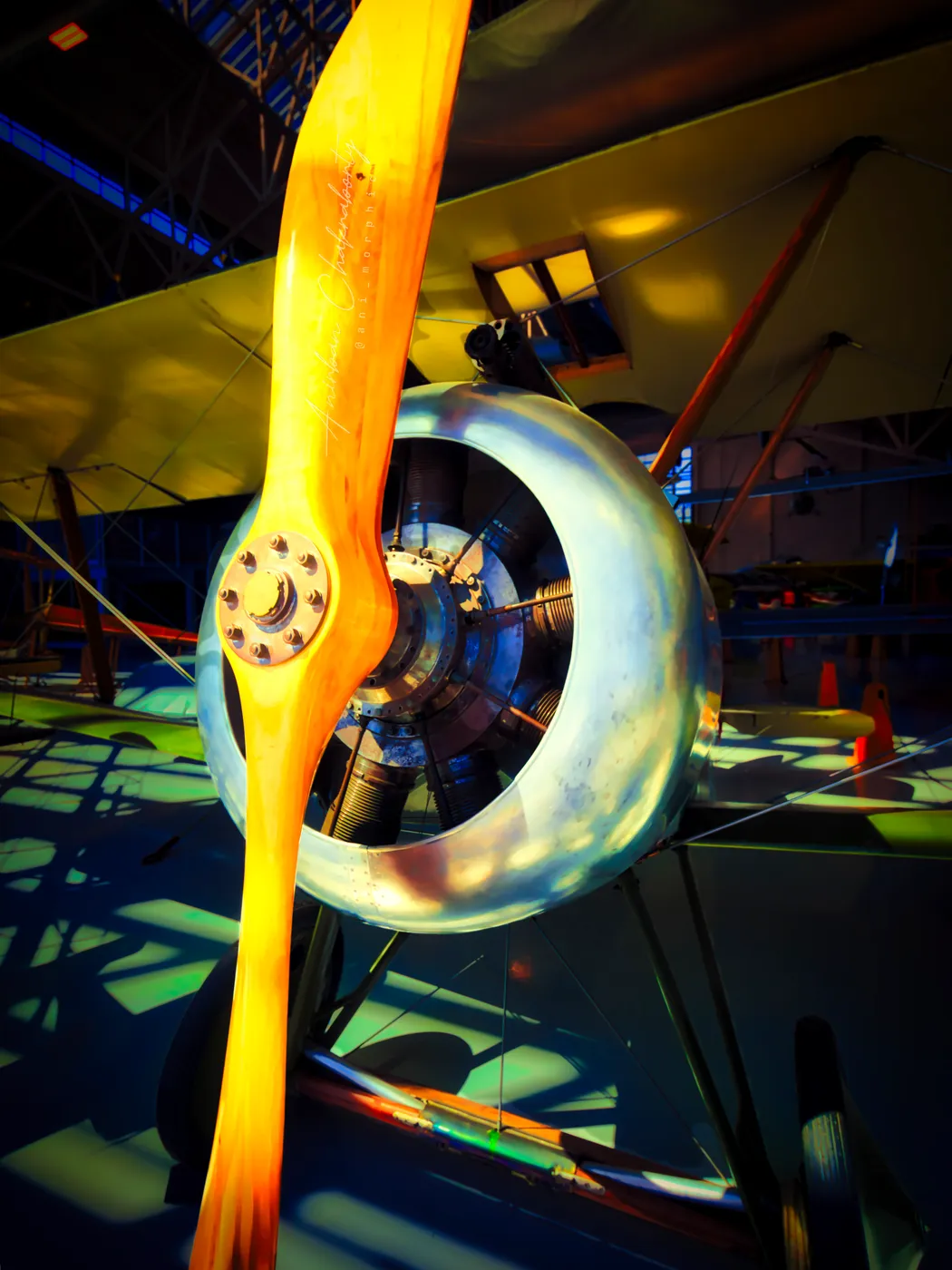 A laminated wooden propeller standing across a biplane's cowling