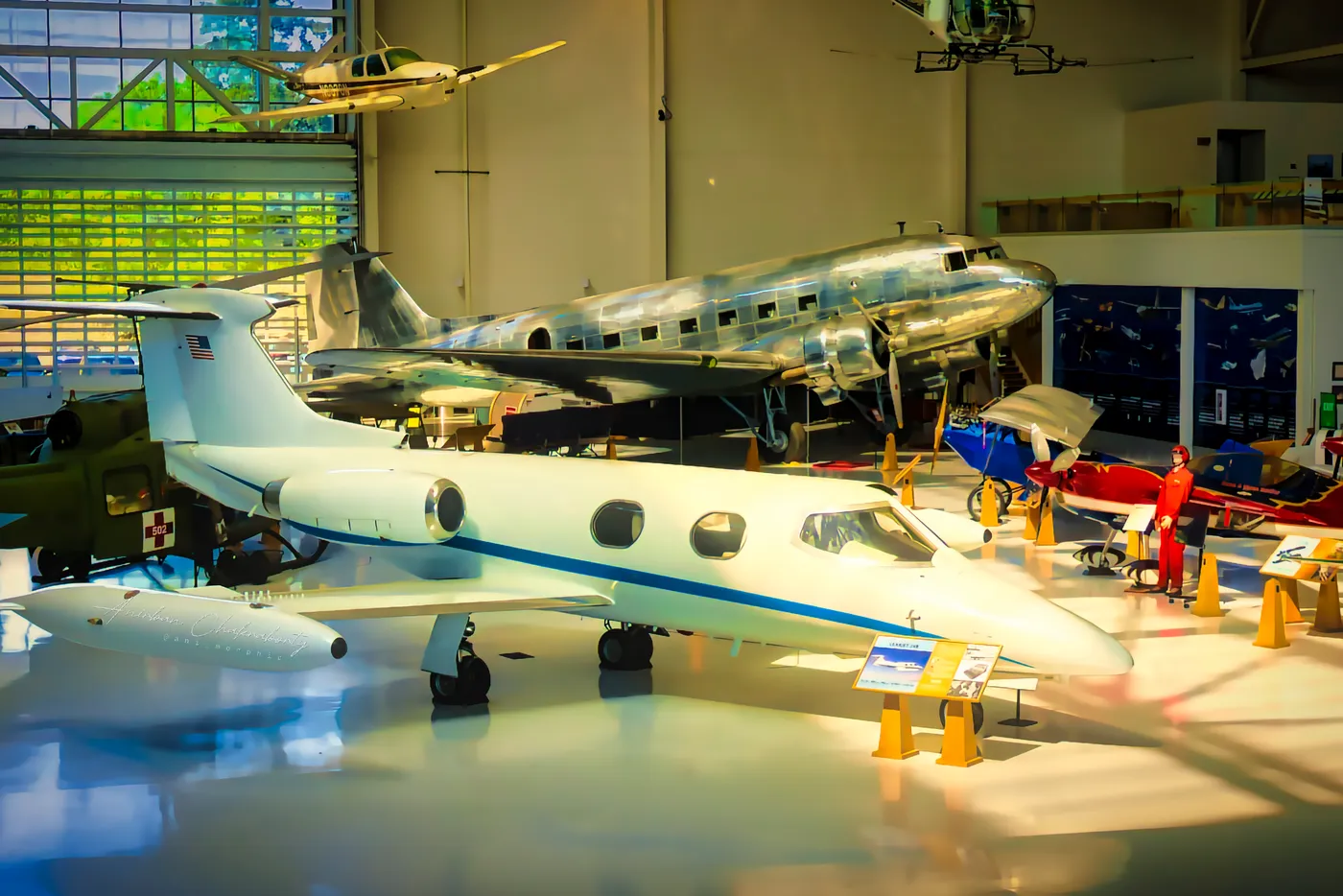 A white executive jet nose to tail with a polished DC-3