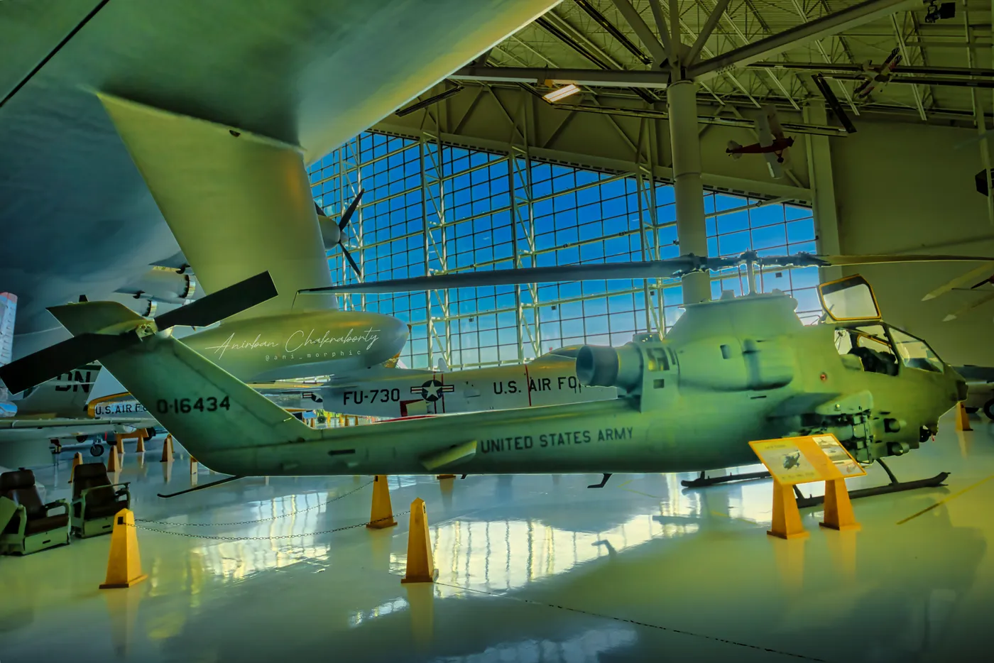 An Army Cobra gunship, blades low under green hangar light