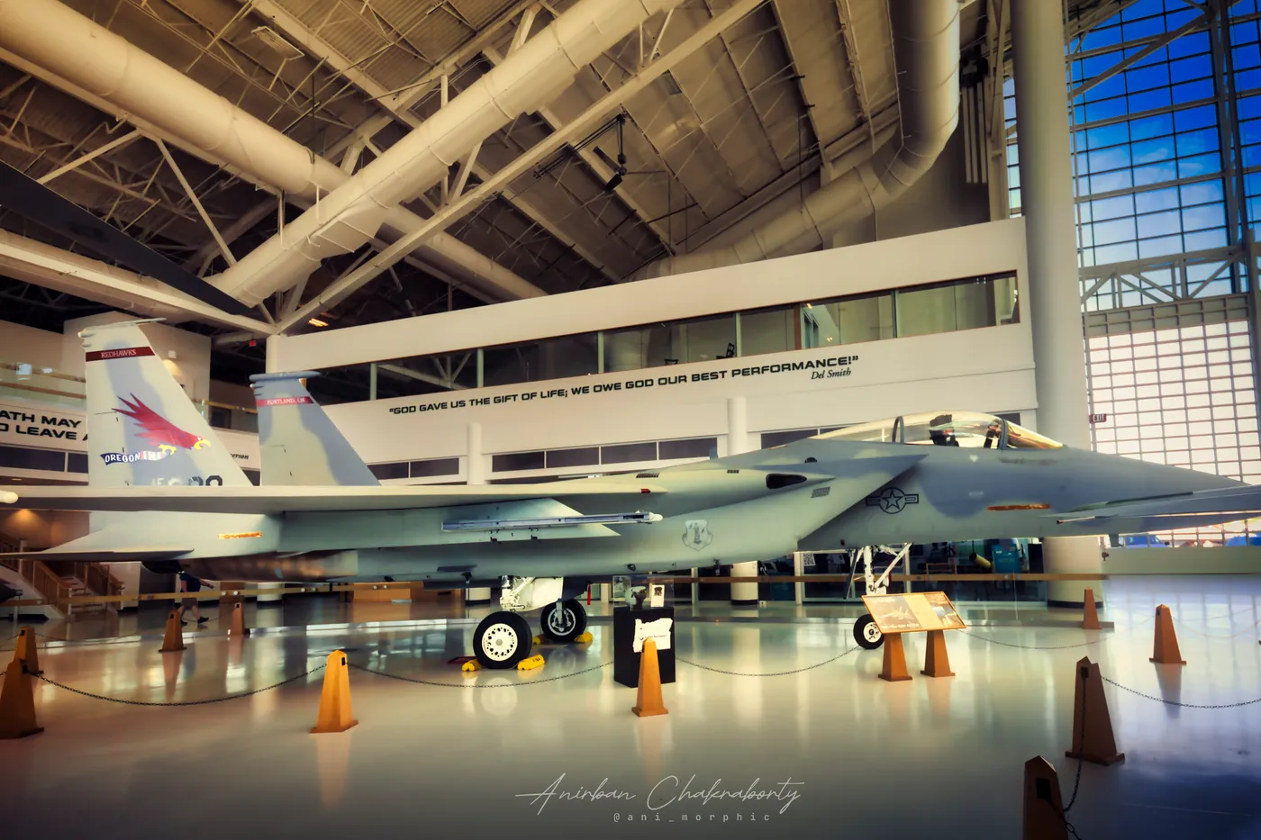 A grey Eagle beneath a quotation painted along the hangar wall